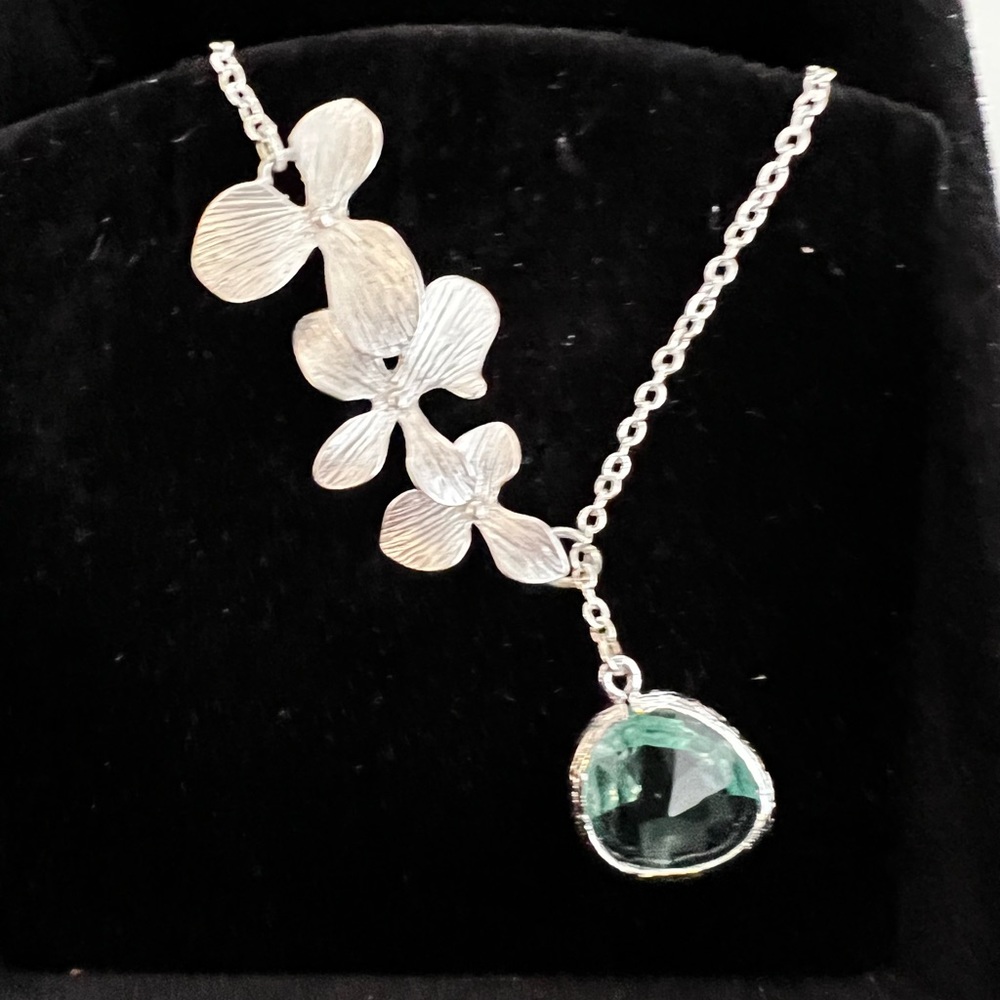 Silver flower necklace with blue topaz drop